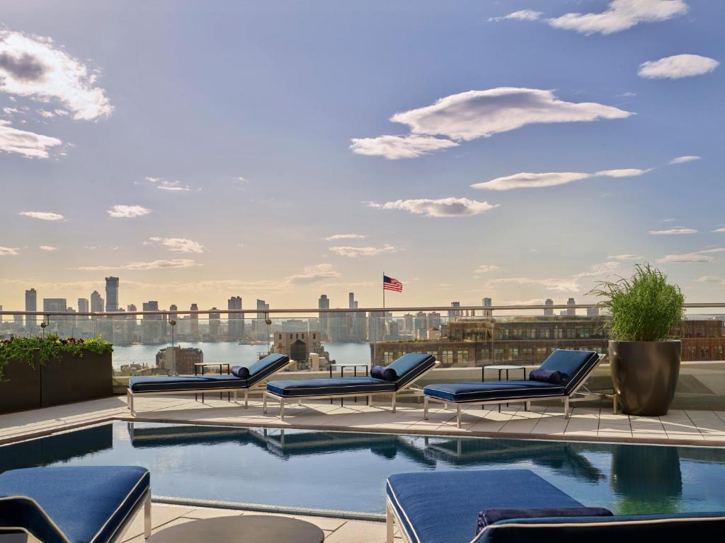 a pool on the roof of a building with the skyline at ModernHaus SoHo in New York