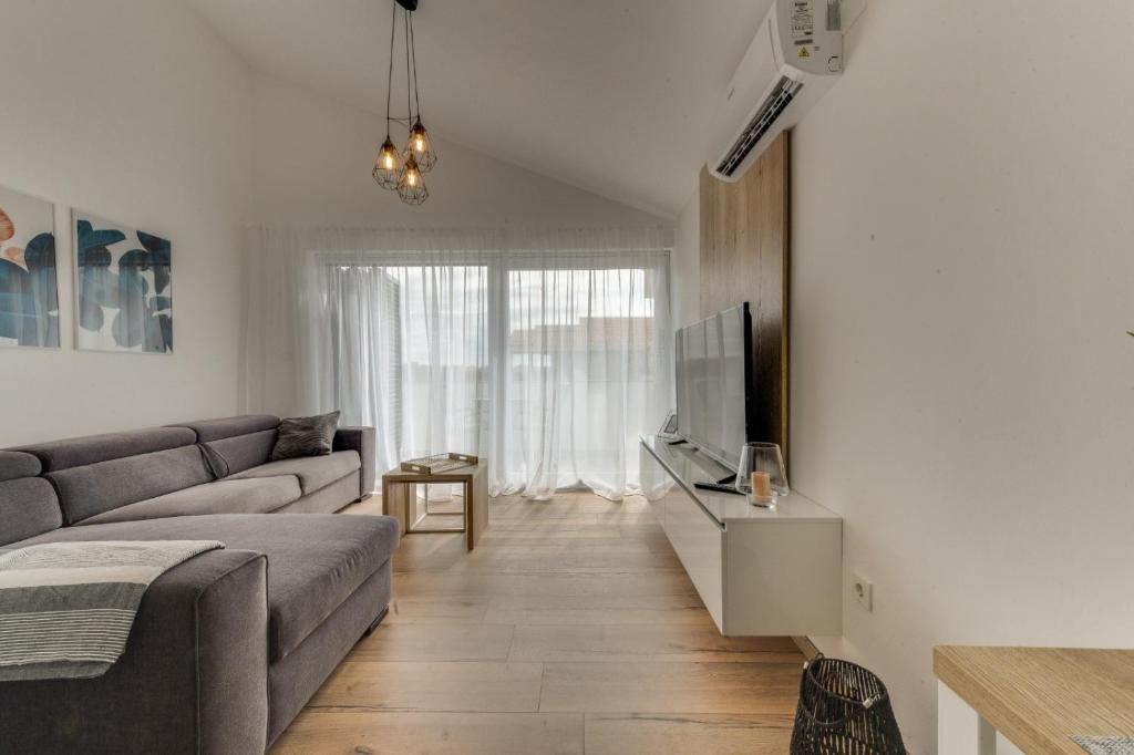 a living room with a couch and a tv at Apartmani Bella Luce in Pašman