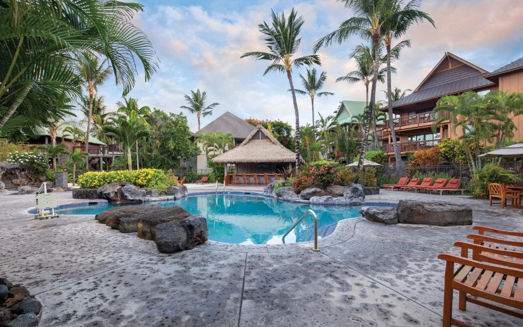 - une piscine dans un complexe avec des palmiers dans l'établissement Wyndham Kona Hawaiian Resort, à Kailua-Kona