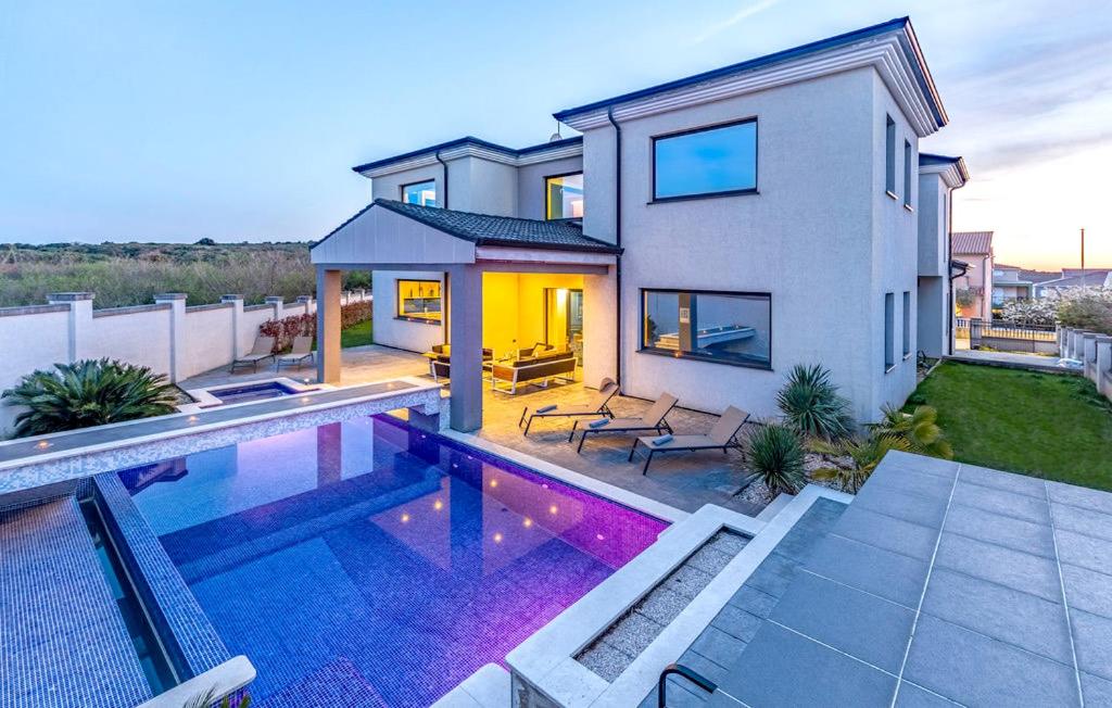 a house with a swimming pool in front of a house at Exclusive VILLA Volme in Banjole