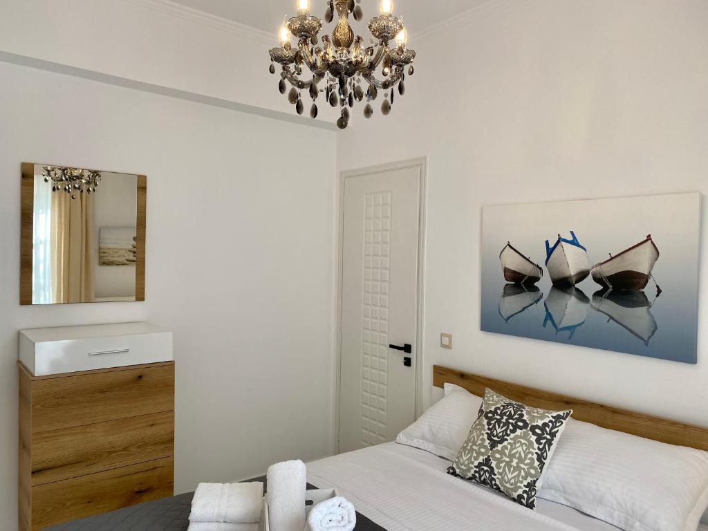 a bedroom with a bed and a chandelier at PORTA HOME modern and hospitable in Naxos Chora