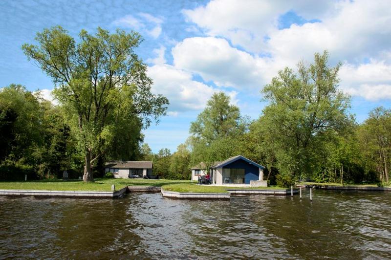 a cabin on the side of a river at Bungalow op eiland in Loosdrecht