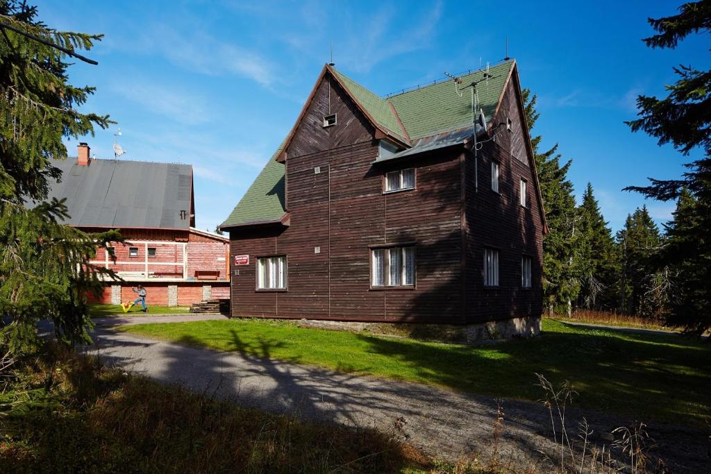 a large wooden house with a green roof at Kábrtova bouda in Janske Lazne