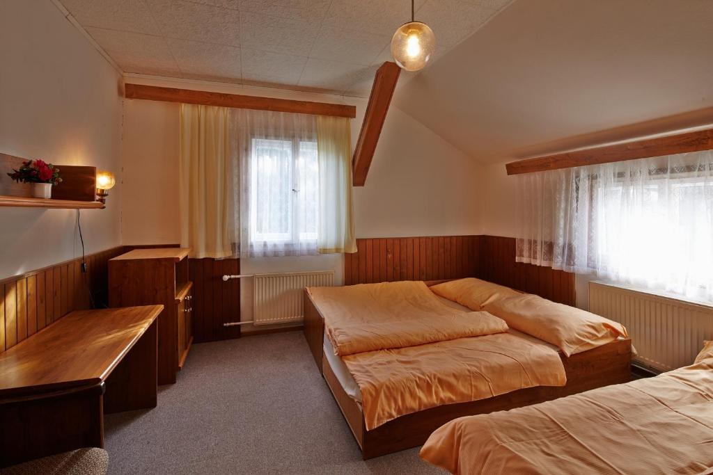 Postel nebo postele na pokoji v ubytování Kábrtova bouda