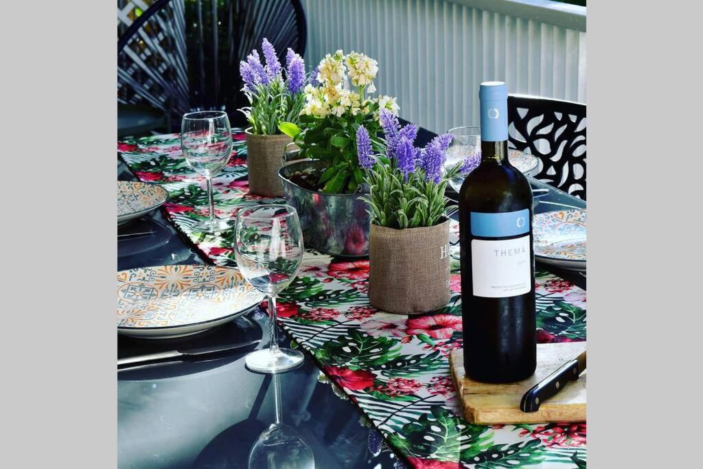 uma garrafa de vinho sentada numa mesa com copos em Tropicana em Atenas