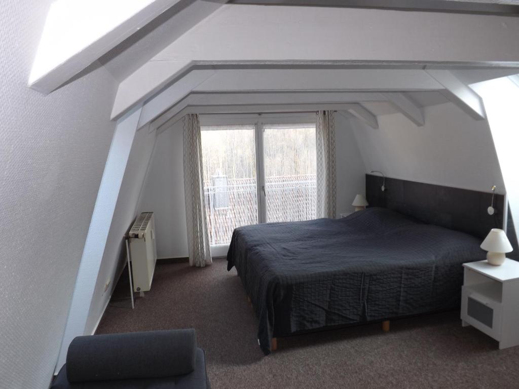 una camera da letto con un letto e una grande finestra di Residenz Bocksberg-Blick & St. Florian a Hahnenklee-Bockswiese