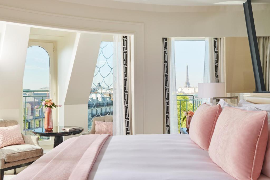 a bedroom with a bed with a view of the eiffel tower at InterContinental Paris Le Grand by IHG in Paris