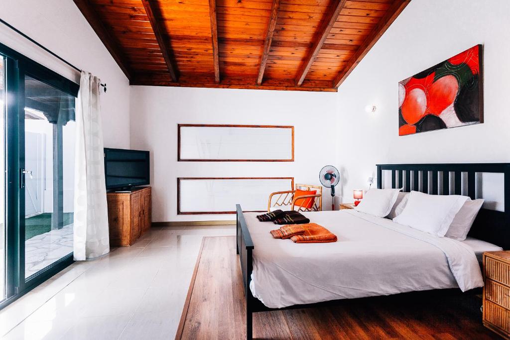 ein Schlafzimmer mit einem großen Bett und einem TV in der Unterkunft Casa Higuereta II in Corralejo