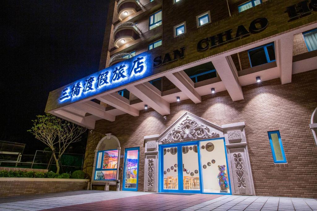 um edifício com um sinal azul no lado em San Chiao Hotel em Daxi