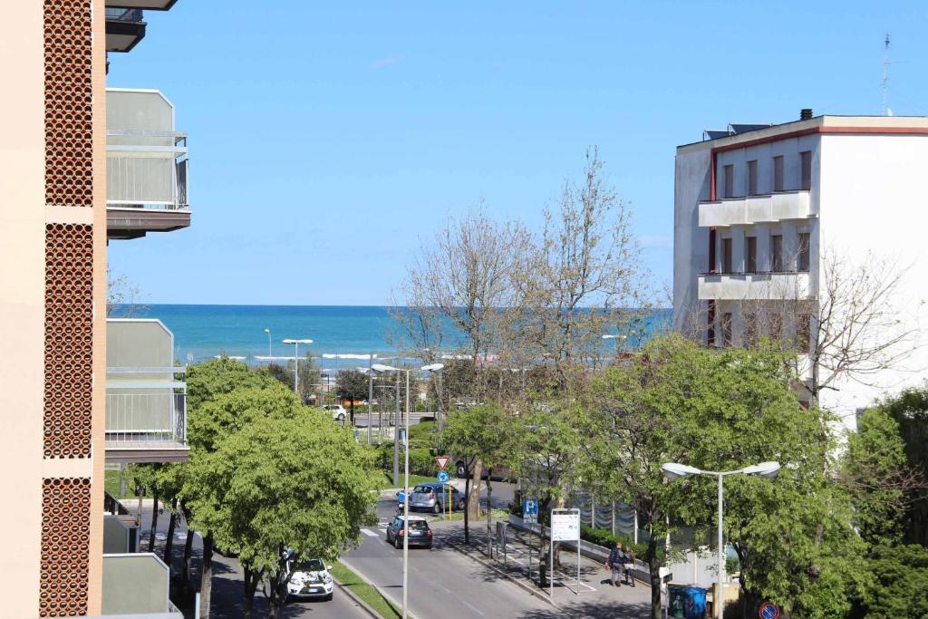 a view of a street with the ocean in the background at Hotel Le Ali in Rimini