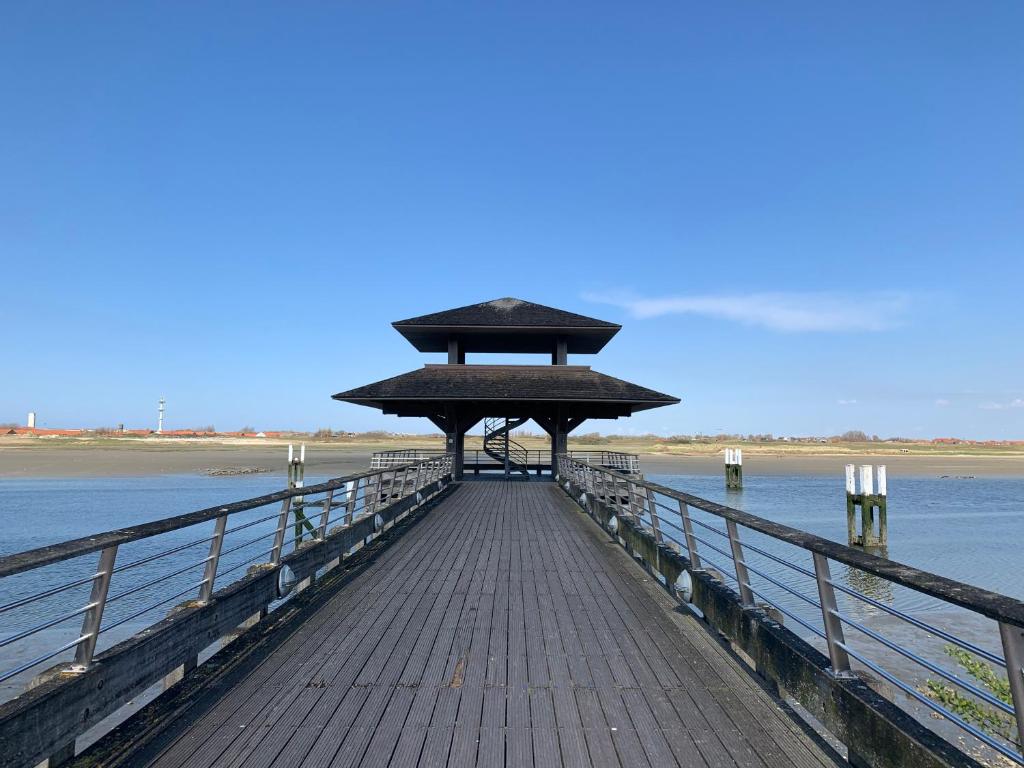 a pier with a building on top of the water at Ysermonde Fisherman's Cottage in Nieuwpoort