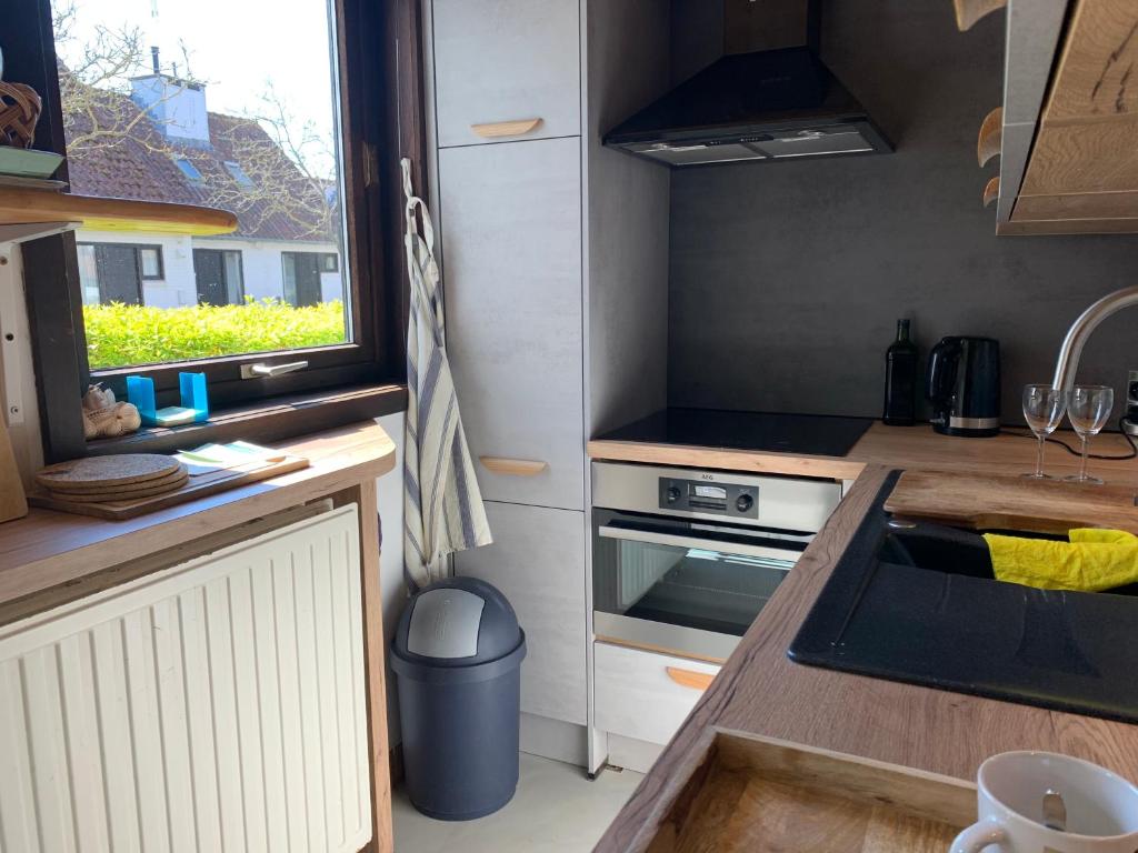 a small kitchen with a sink and a stove at Ysermonde Fisherman's Cottage in Nieuwpoort