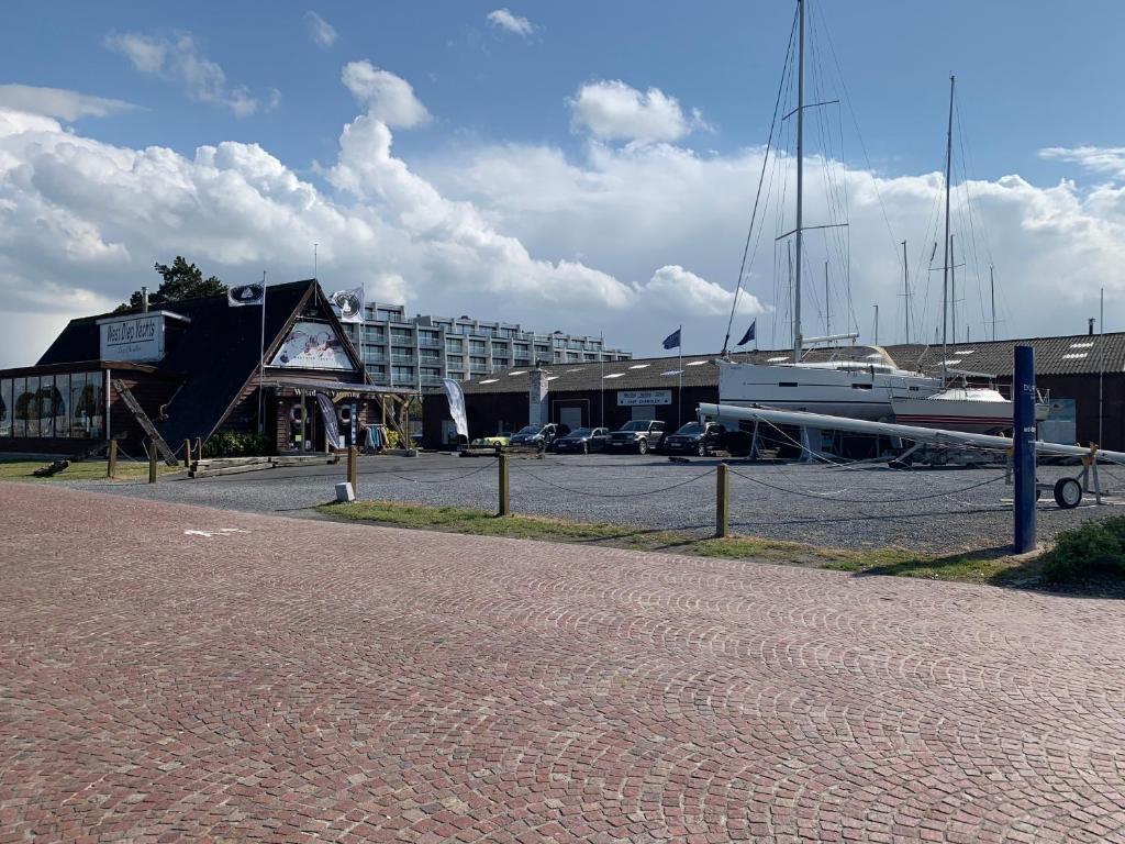 a marina with a large building and a boat at Ysermonde Fisherman's Cottage in Nieuwpoort