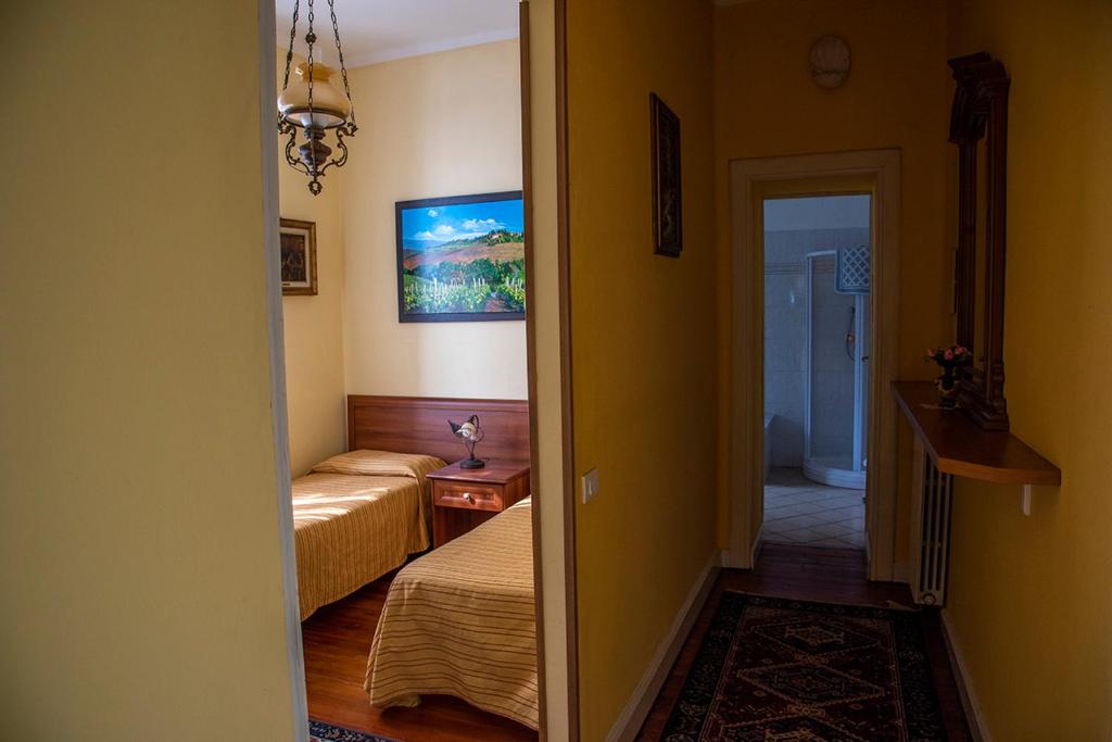 a small room with two beds and a hallway at Hotel Villa Ruscello in Baveno
