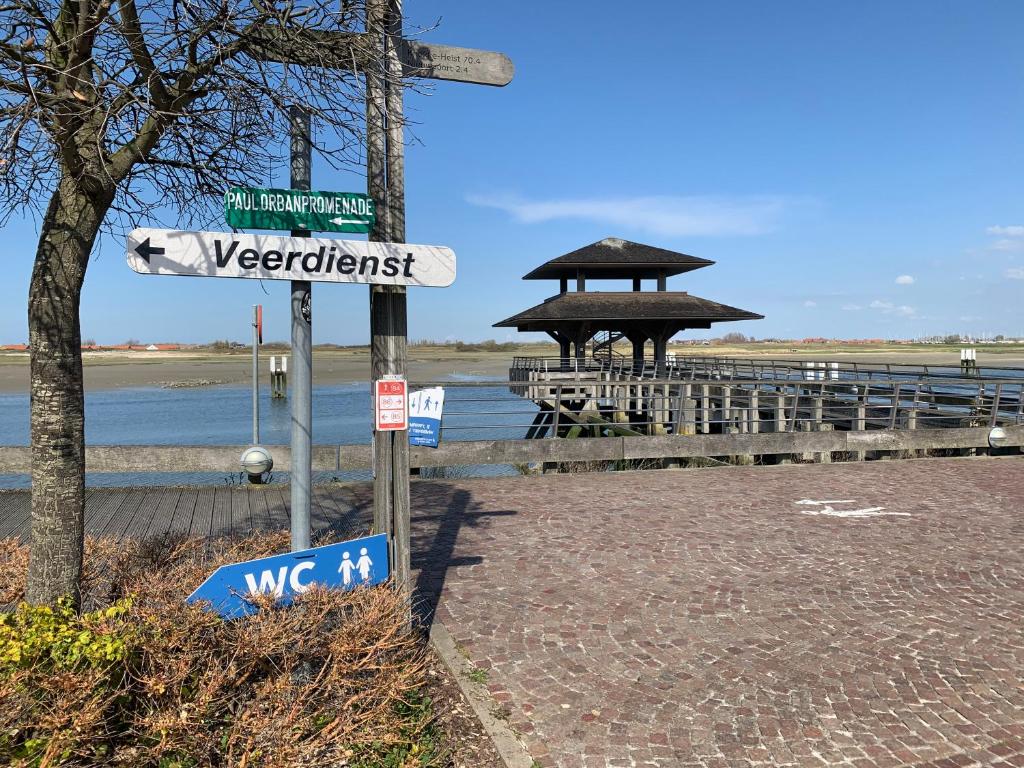 a street sign in front of a pier at Ysermonde Fisherman's Cottage in Nieuwpoort