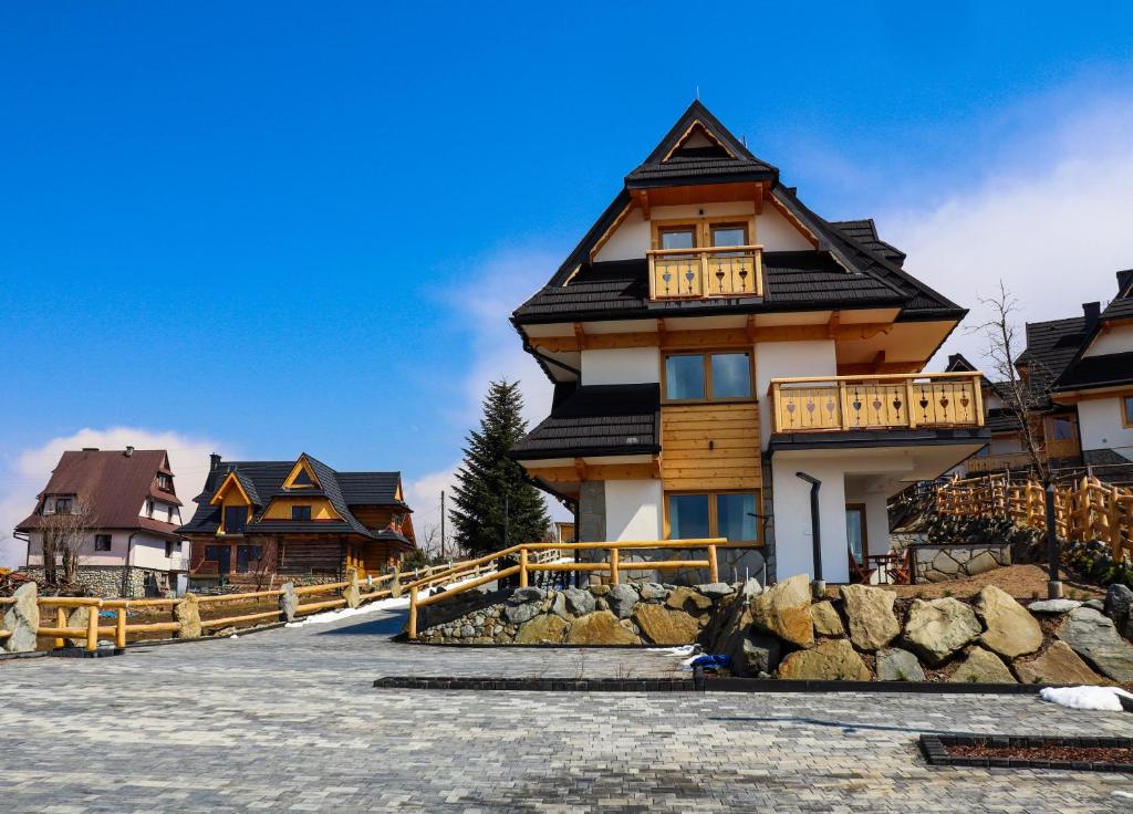 ein großes Holzhaus mit einem Zaun davor in der Unterkunft Tatrzanska Polana - Mountain View, Free Parking & WiFi in Zakopane