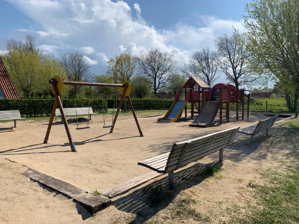 a park with a playground with benches and a slide at Ysermonde Fisherman's Cottage in Nieuwpoort
