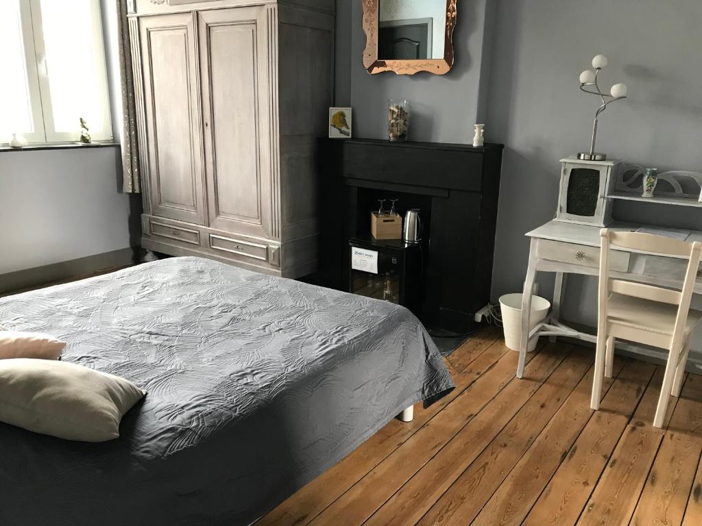 a bedroom with a bed and a desk with a microwave at Liotte'sCorner Guesthouse in Sprimont