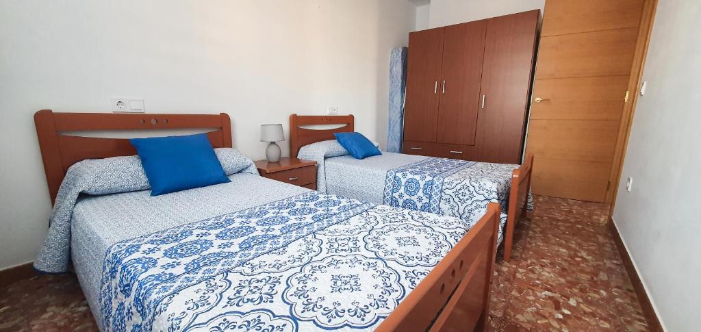 um quarto com 2 camas com lençóis azuis e brancos em Villa del Carmen em Almayate Alto