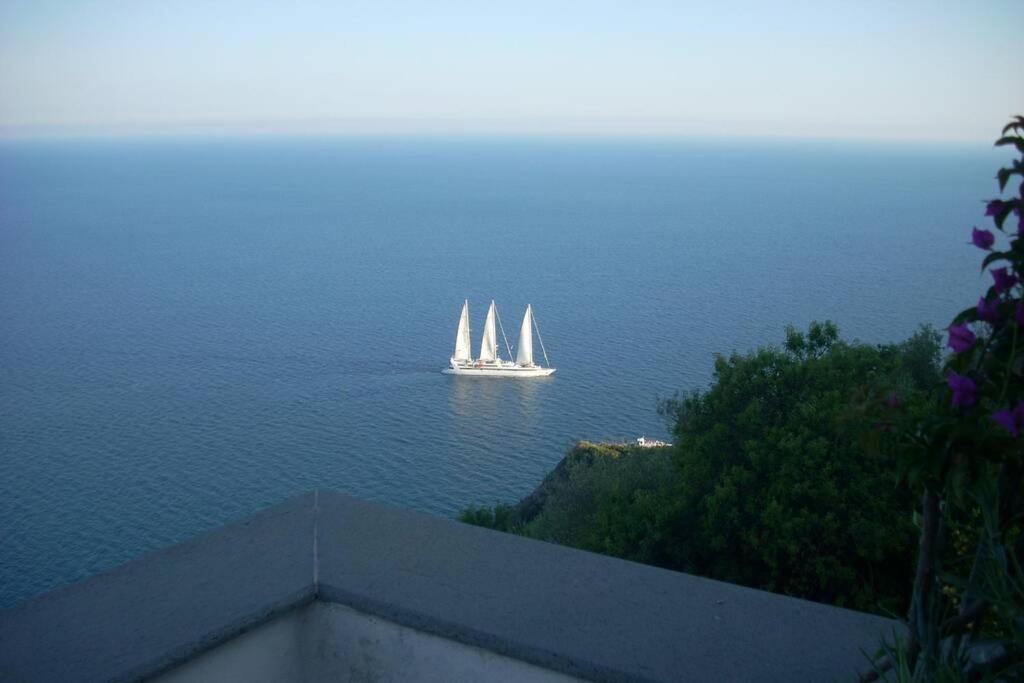 a boat with three sails in the water at East wind house in Praiano