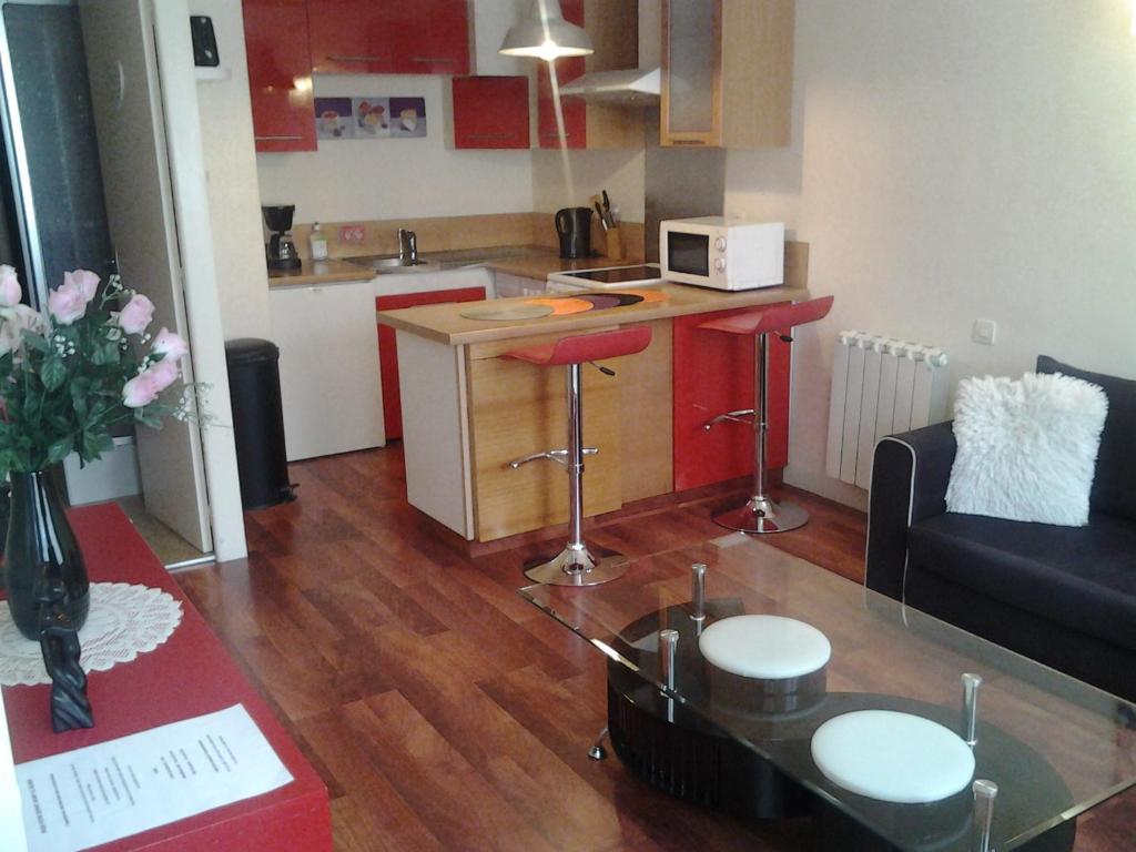 un salon avec une table et une cuisine dans l'établissement Appartement Rue Nationale - Port de la houle, à Cancale