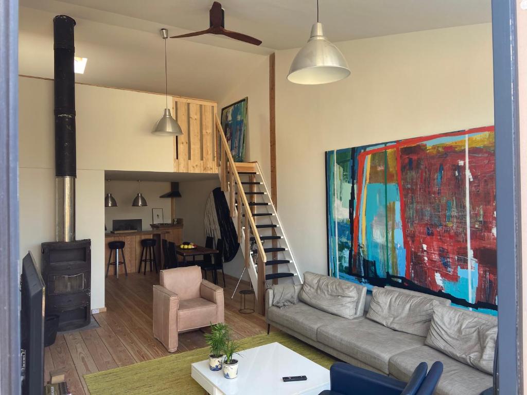 uma sala de estar com um sofá e uma pintura na parede em Luca’s Loft em Bergen