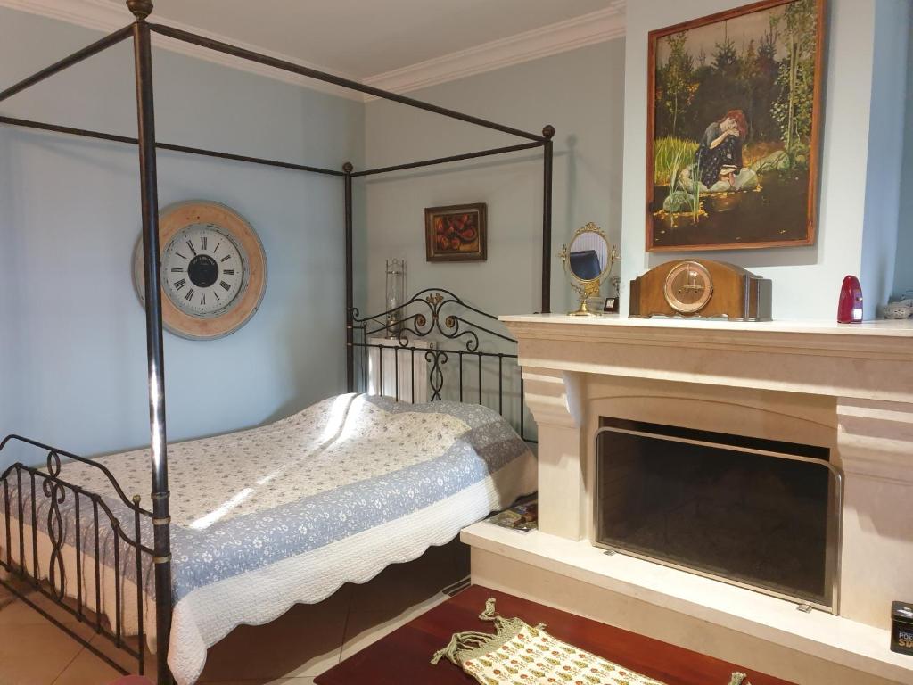 ein Schlafzimmer mit einem Himmelbett und einem Kamin in der Unterkunft Apartment in Anakasia overlooking Volos in Volos