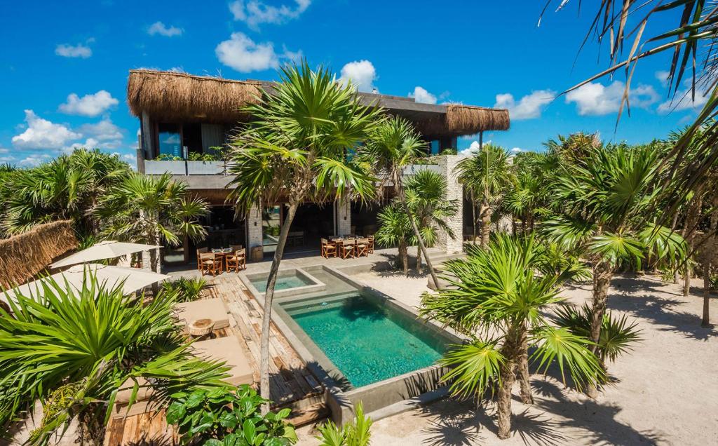 an aerial view of a resort with a swimming pool and palm trees at Beachfront Villa in Tankah Bay in Tulum