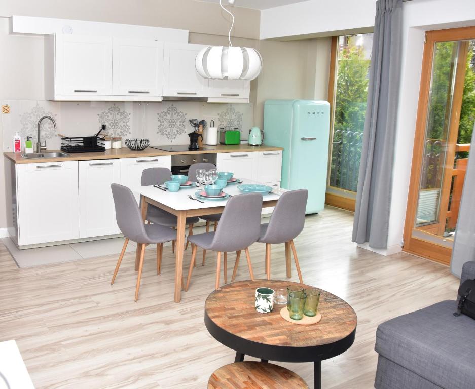 a kitchen and living room with a table and chairs at Apartament Erica in Zakopane