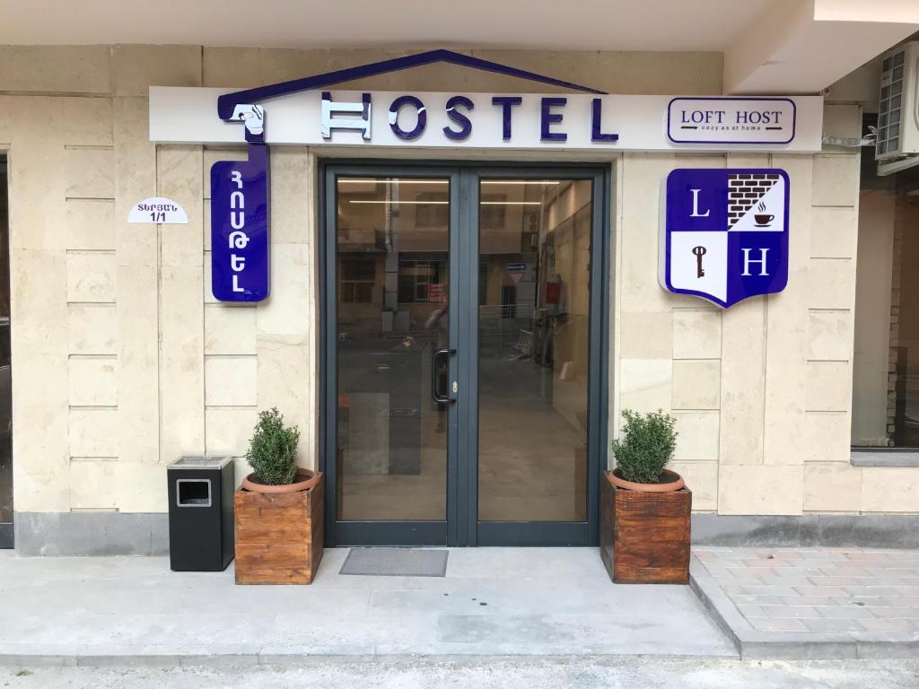 a hospital entrance with two potted plants in front of it at Loft Host Yerevan in Yerevan