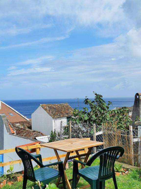 a table and chairs on a balcony with the ocean at The Handmade House Azores in Porto Formoso