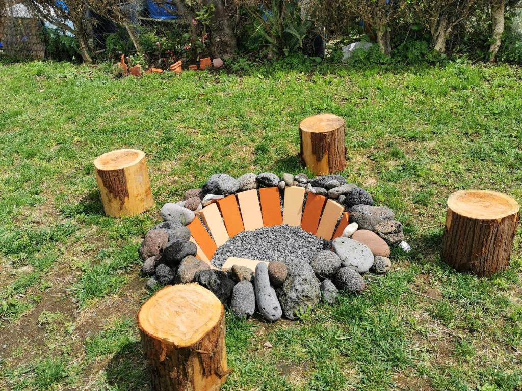 a bench sitting in the middle of some logs at The Handmade House Azores in Porto Formoso