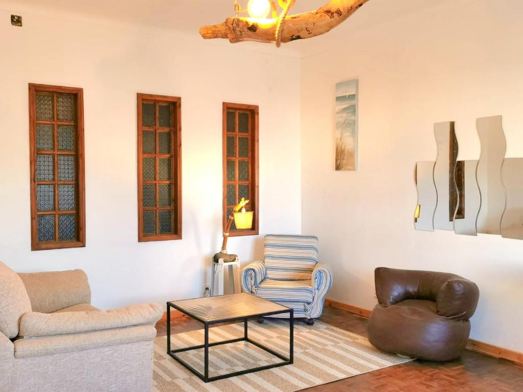 a living room with two chairs and a table at The Handmade House Azores in Porto Formoso