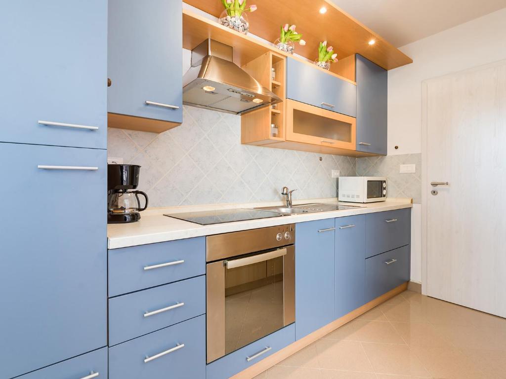 a kitchen with blue cabinets and a sink at Porec TWINS Apartment in Poreč