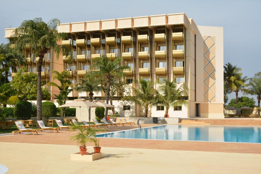 a hotel with a swimming pool in front of a building at Hala Hotel & Aqua Park in Bissau