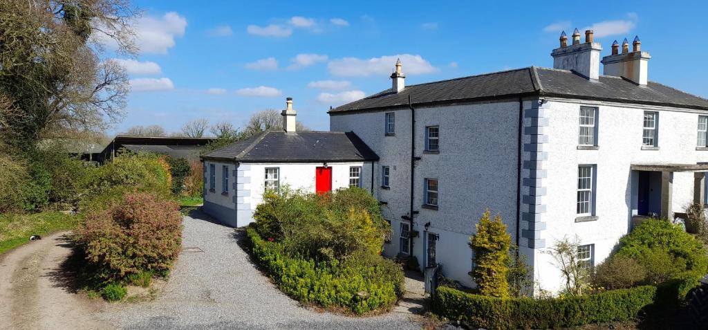 a house with a red door on the side of it at Gormanstown House Apt, The Island in Tullamore