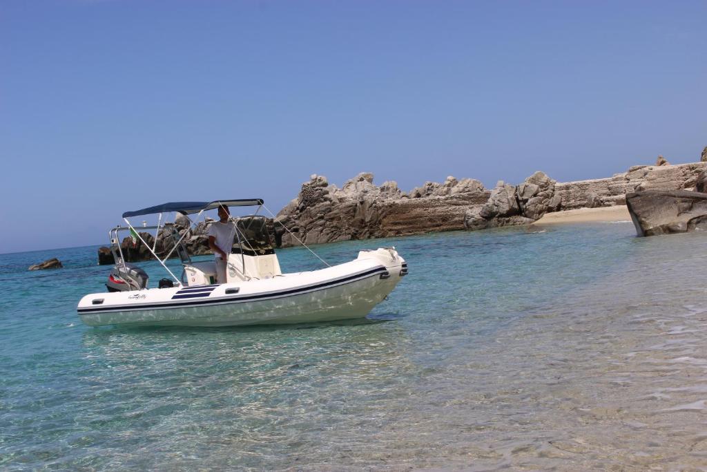 a boat sitting in the water on a beach at Borgo di Santa Barbara in Santa Domenica