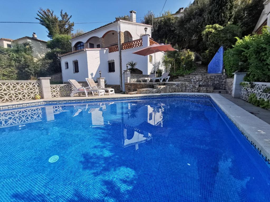 una villa con piscina di fronte a una casa di El Pájaro a Pals