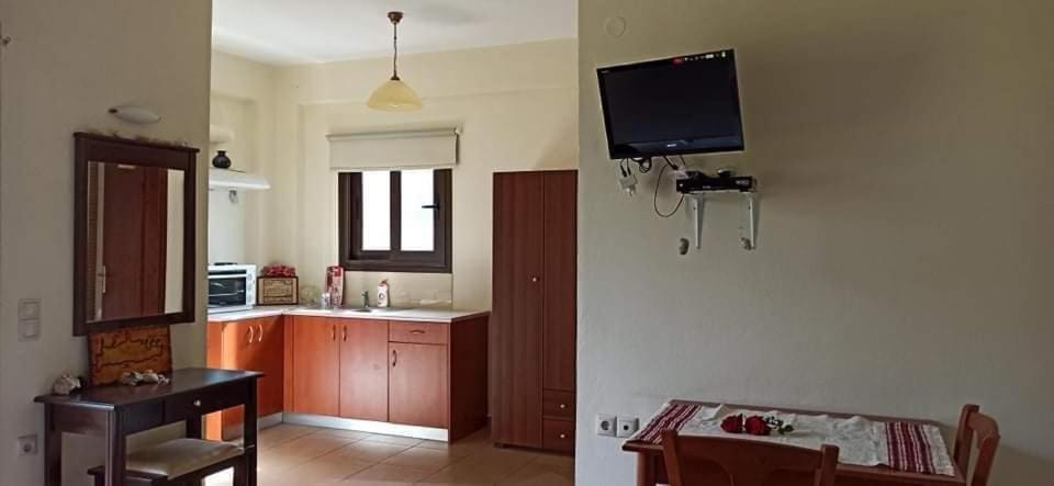 a kitchen with a tv on the wall and a table at Xenonas Anopolis 1 in Anopoli Sfakion