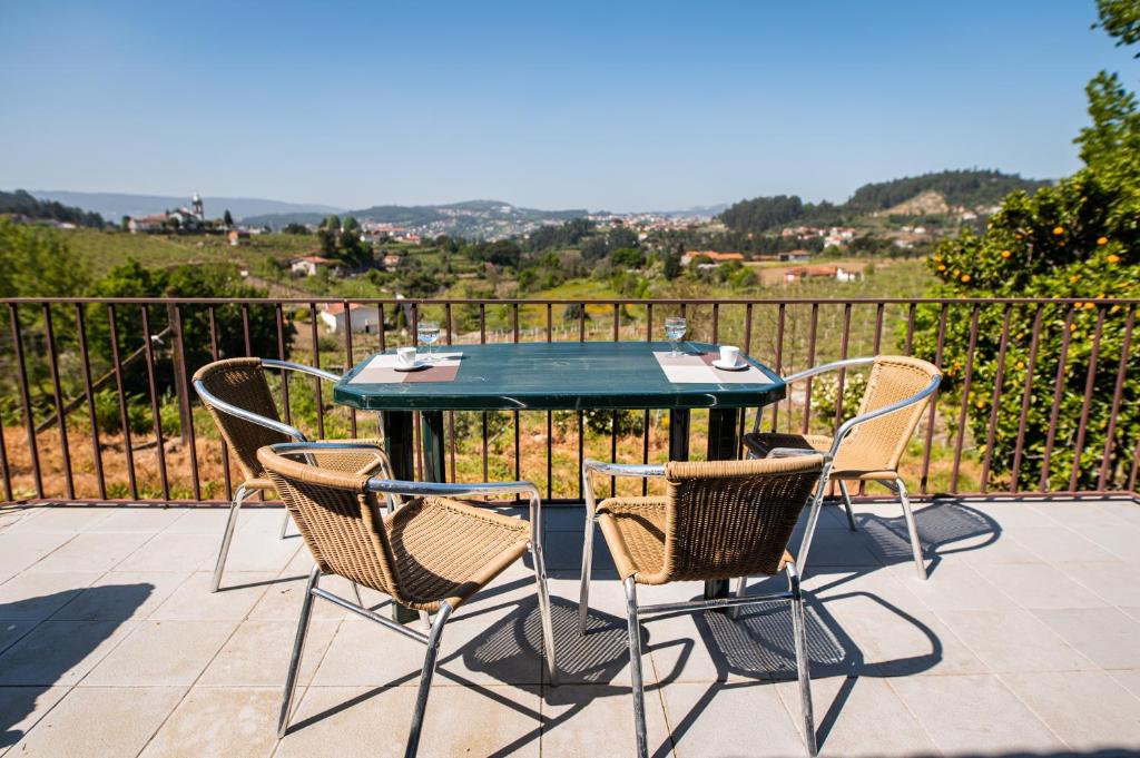a table and chairs on a patio with a view of a hill at Partezins III in Castelo de Paiva