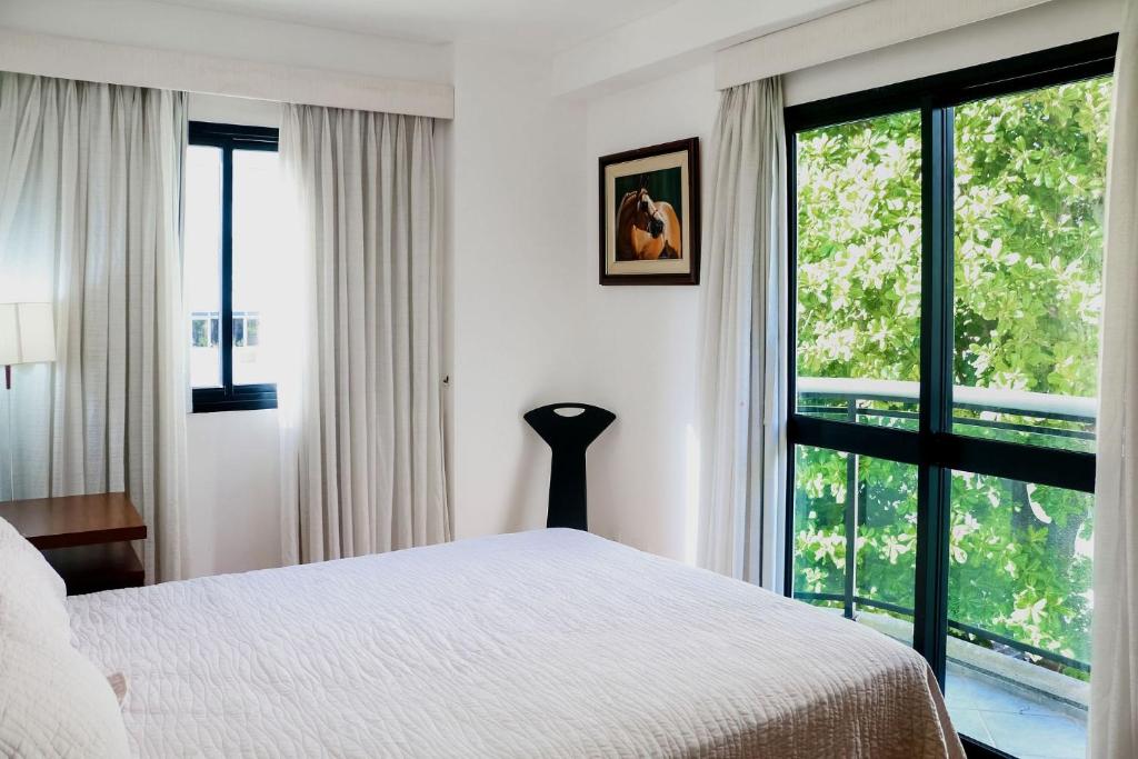 - une chambre avec un lit et une grande fenêtre dans l'établissement Rio Sunset Arpoador!, à Rio de Janeiro