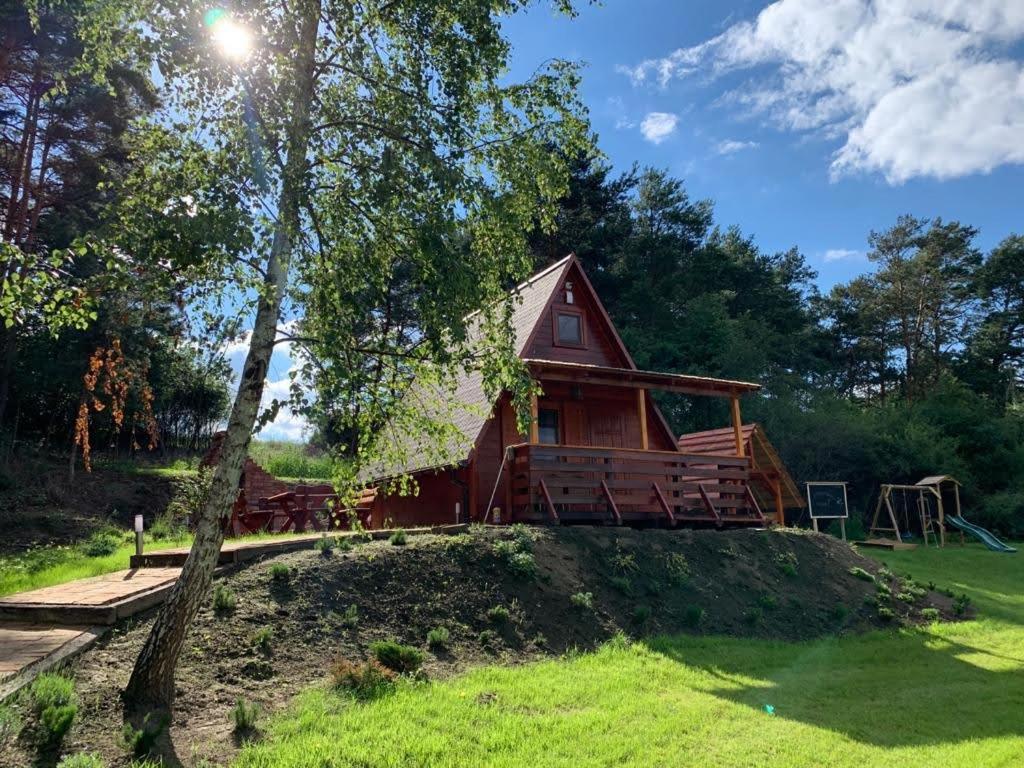 una cabaña en el bosque con parque infantil en Lawendowy Brzeg, en Jaryszewo