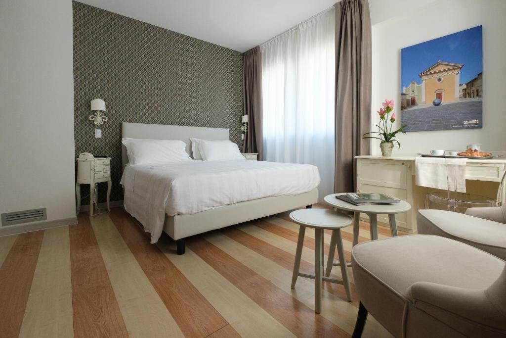 Habitación de hotel con cama, mesa y sillas en Hotel Portavaldera, en Peccioli
