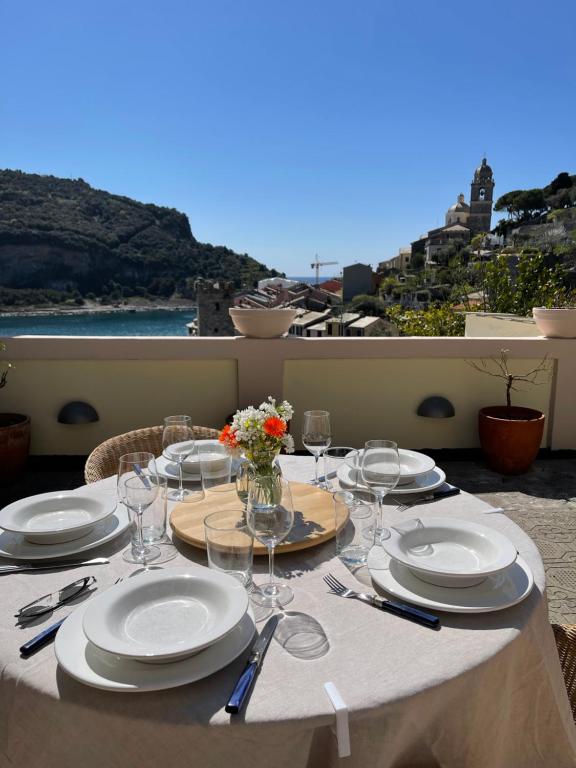 einen Tisch mit Tellern und Weingläsern auf dem Balkon in der Unterkunft Villa Paolo Lemon Tree in Porto Venere