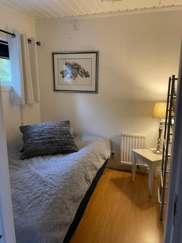 a bedroom with a bed and a table with a lamp at Lillhuset Norr Sälens By in Sälen