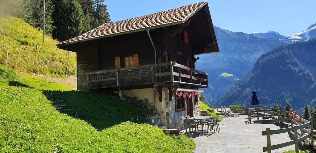 a building on a hill with tables and chairs at Chalet le Grenier - Romantique et exclusif in Champéry