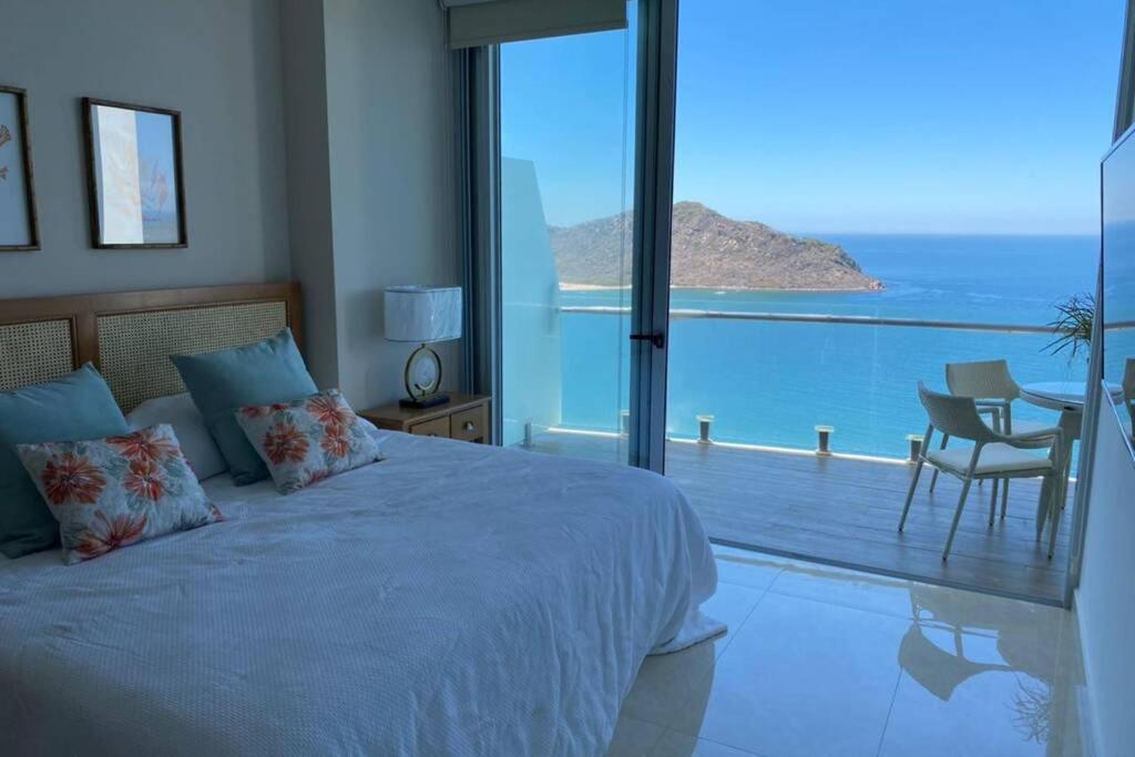 a bedroom with a bed and a view of the ocean at Camino al Mar. Exclusivo depa con vista al mar in Mazatlán