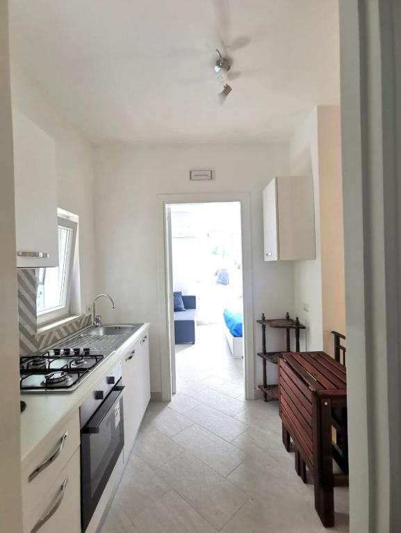 a white kitchen with a stove top oven next to a door at Emidio House in Termini