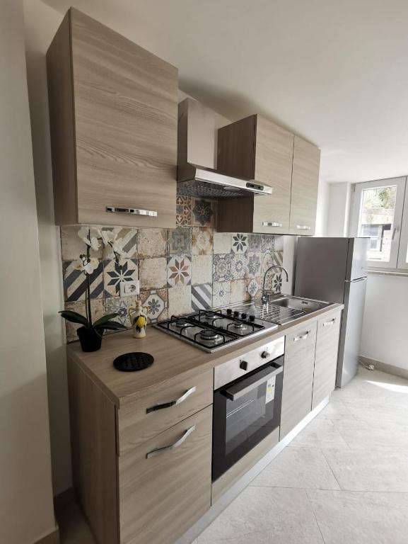 a kitchen with wooden cabinets and a stove top oven at Emidio House in Termini