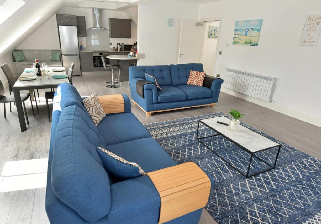 a living room with a blue couch and a table at Pier House Luxury Apartment in Dingle